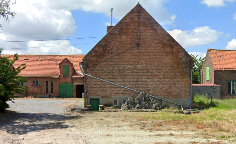 Een Lourdesgrot onderaan tegen de gevel van een boerderijgebouw. Tuimelarestraat 56.